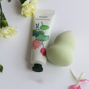non greasy hand cream natural hand cream tube next to a green sponge and flowers.